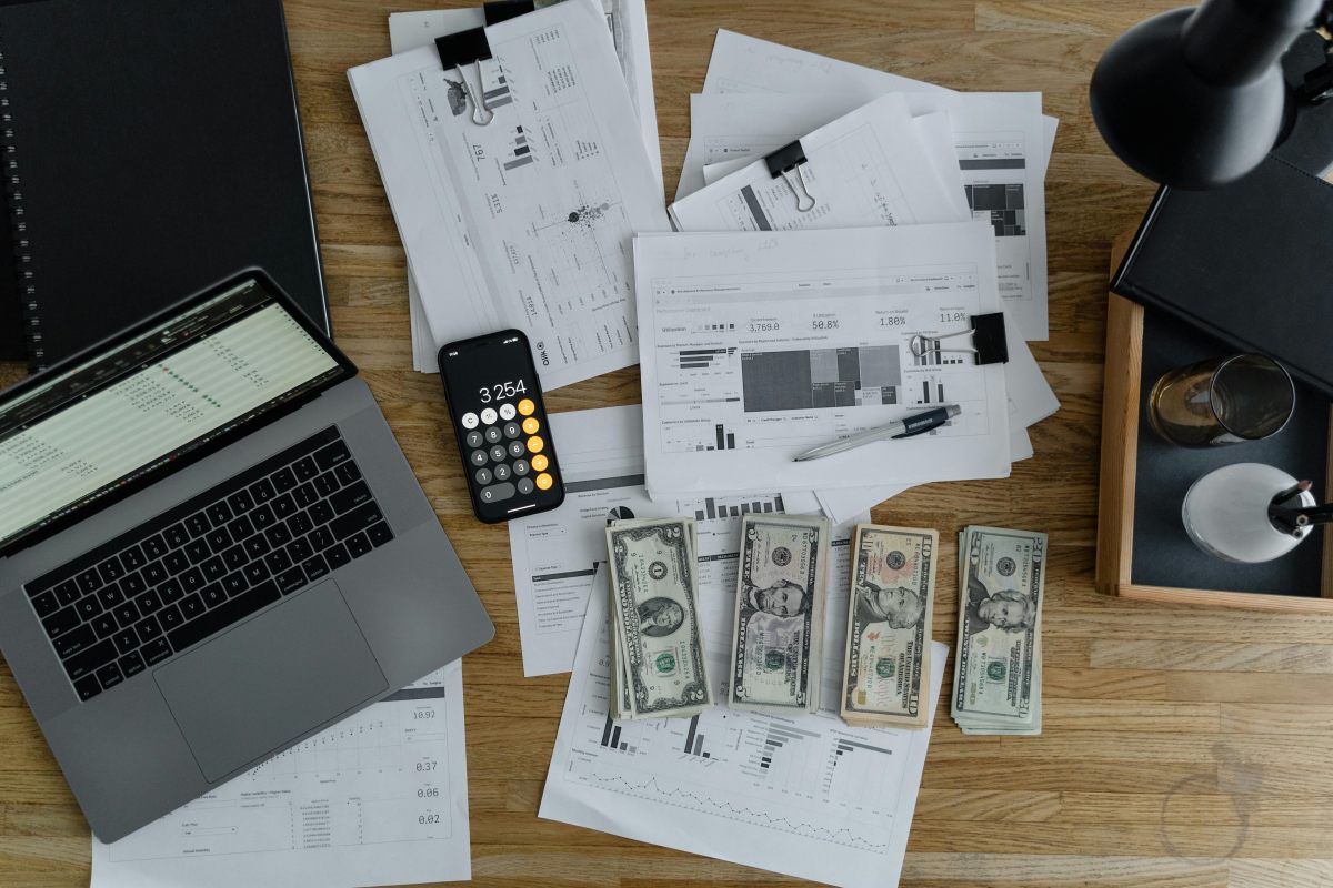 Desk with laptop, documents and money to work out payroll