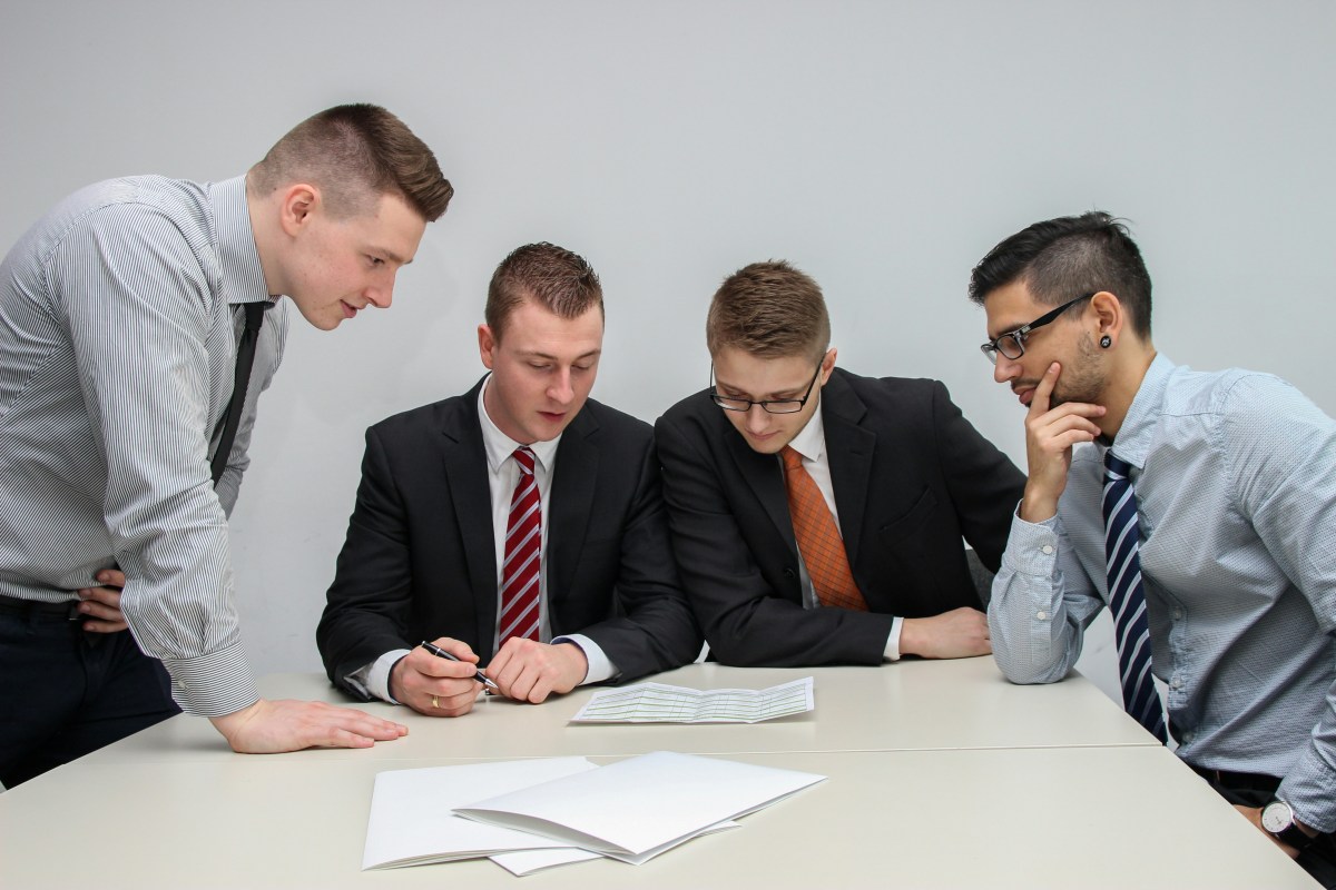 Four men reviewing documents