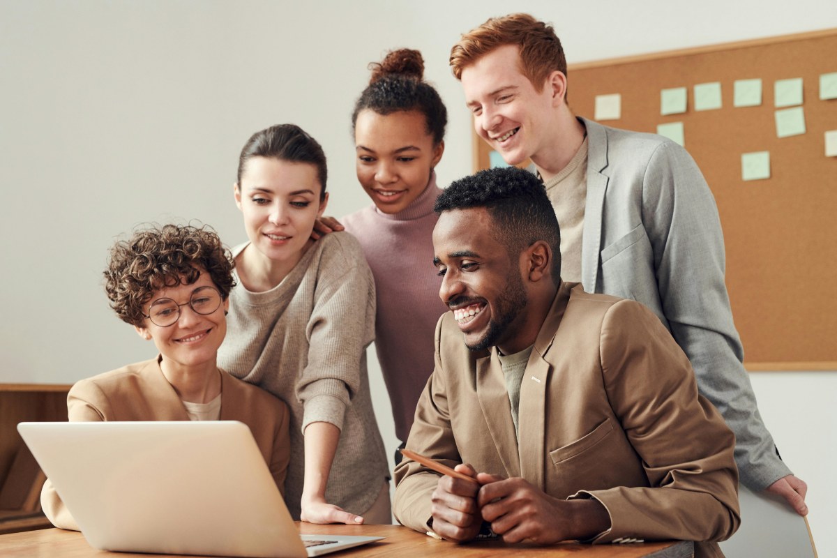 Team happily working together on a laptop