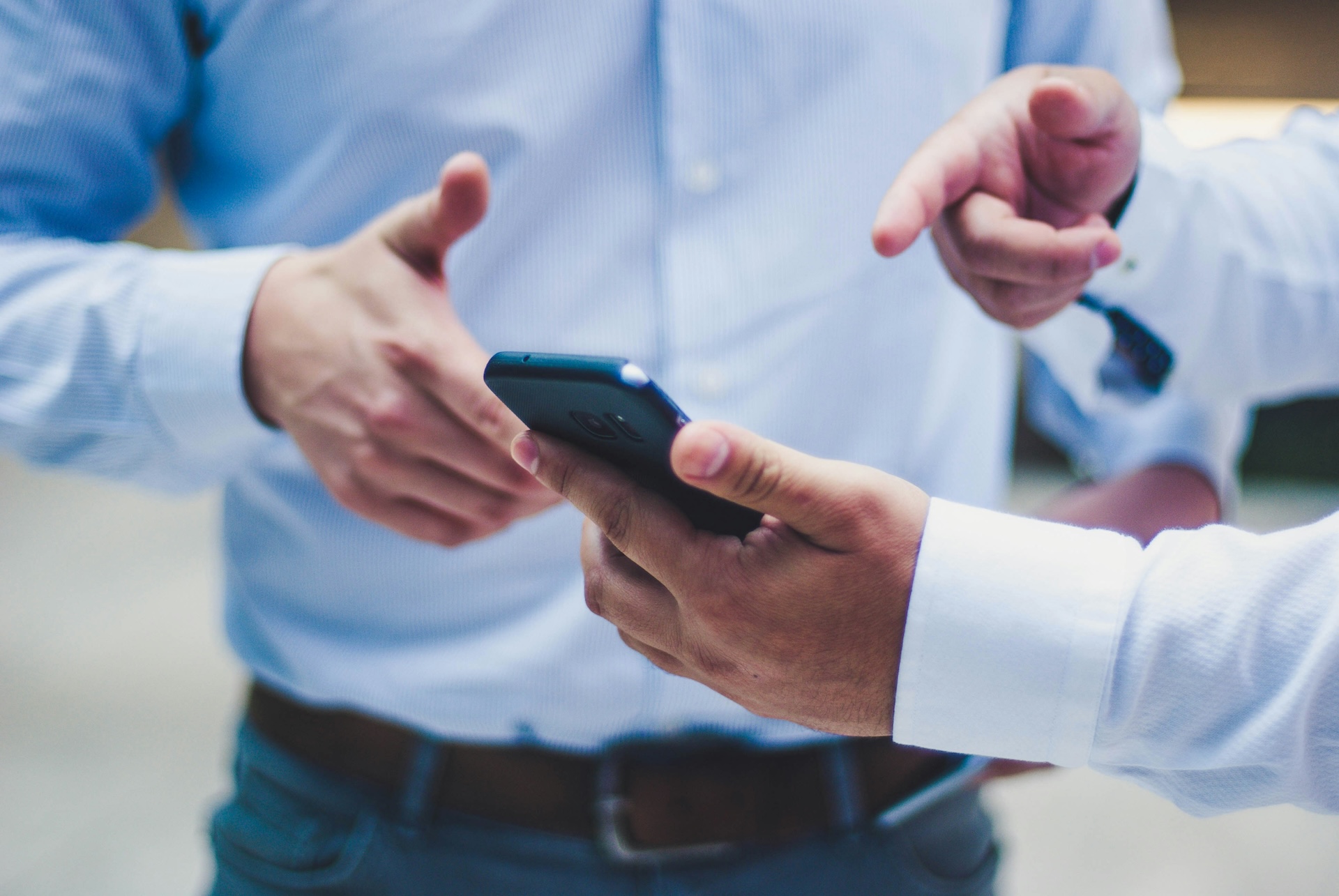 buisness man showing cellphone to friend about paypal working capital loan