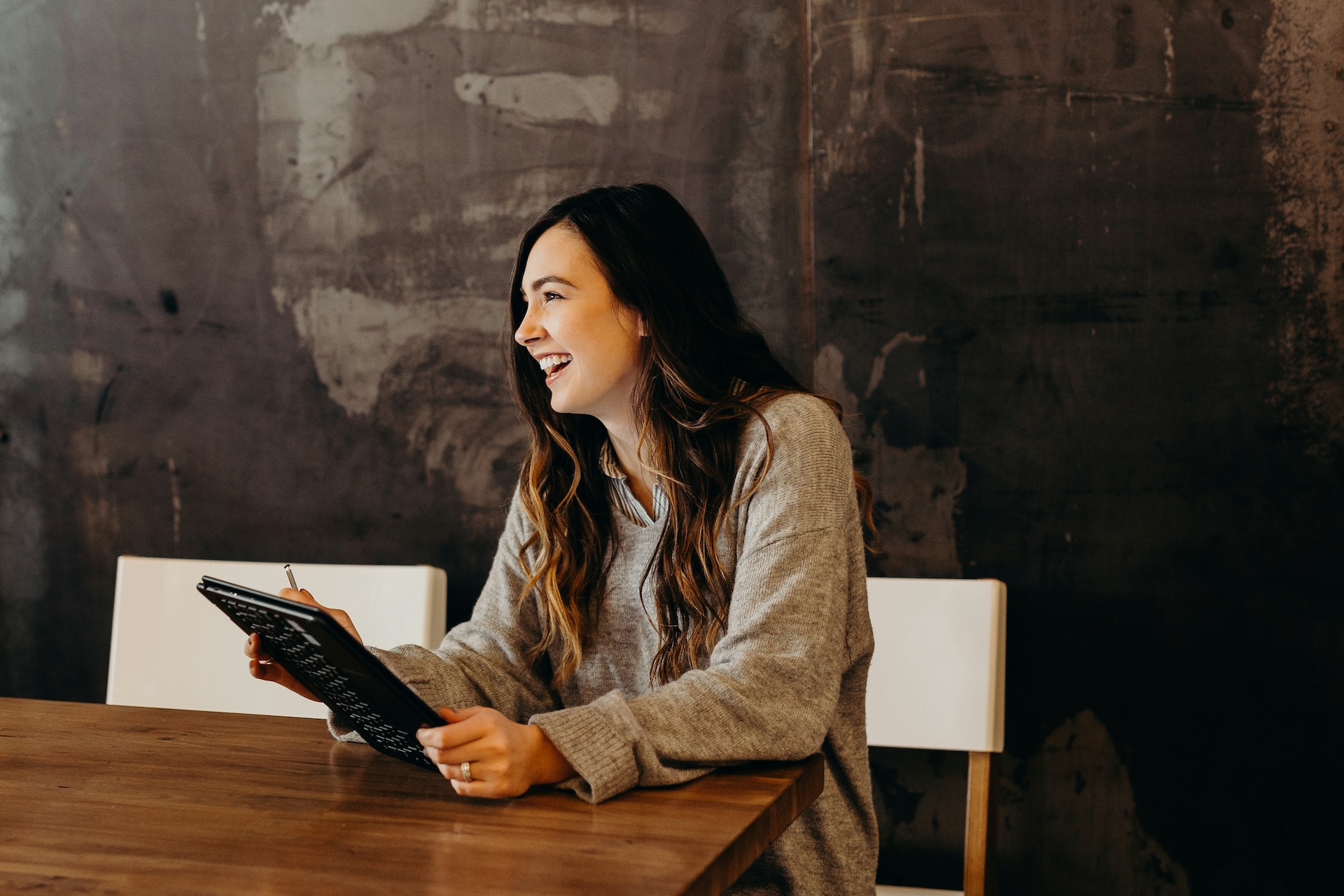 business owner smiling holding tablet because of business loans for bad credit