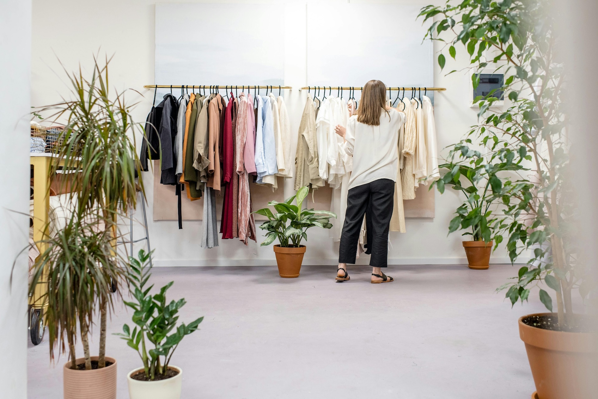 clothing store owner looking over wares to figure out working capital