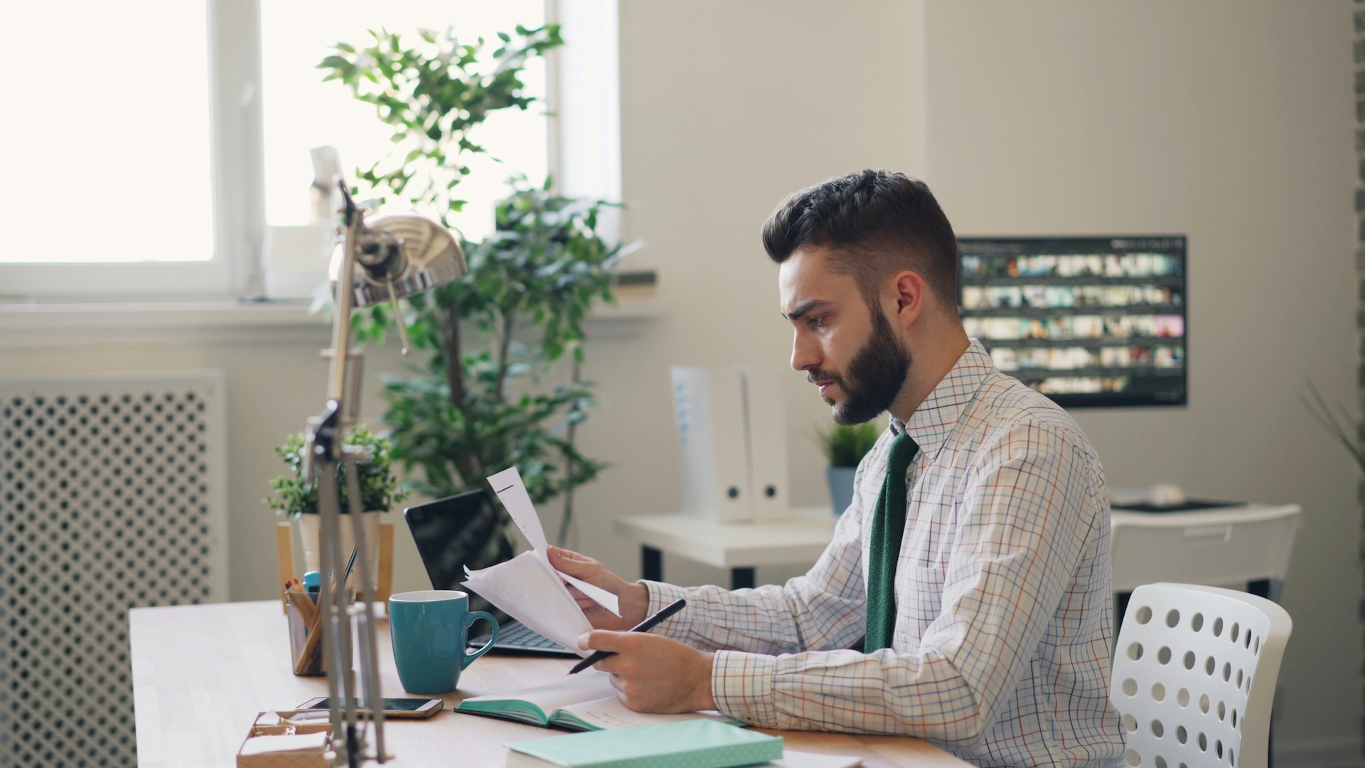 man at computer looking over papers concerning business lines of credit