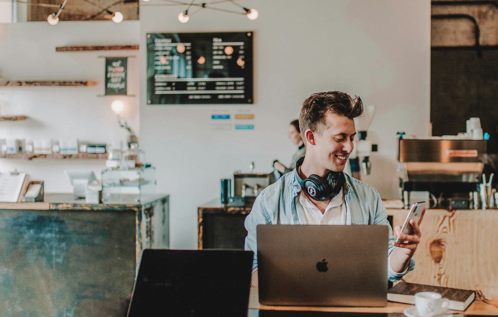 man working on laptop and checking phone about paypal working capital loan