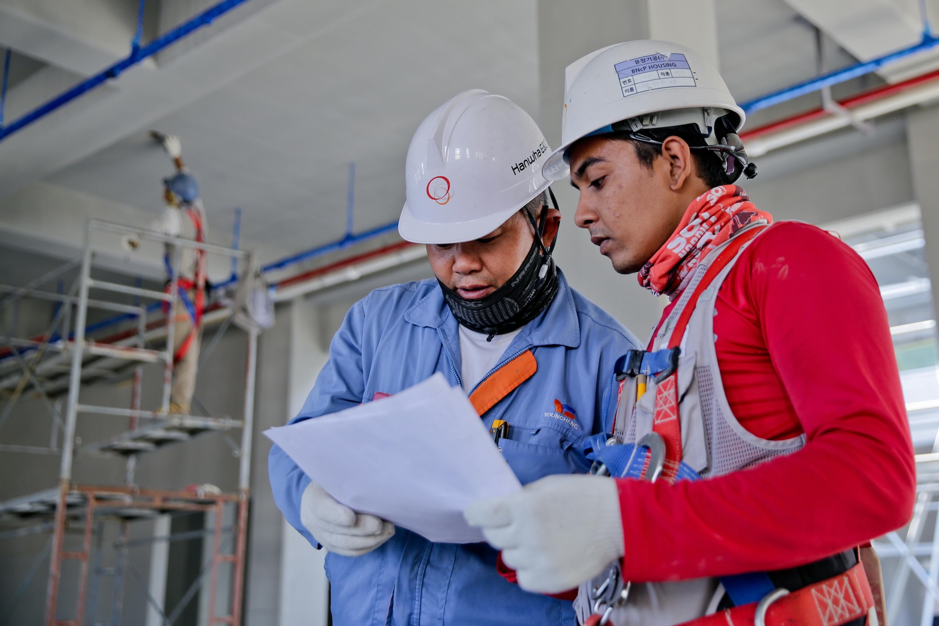 two builders look over construction plans