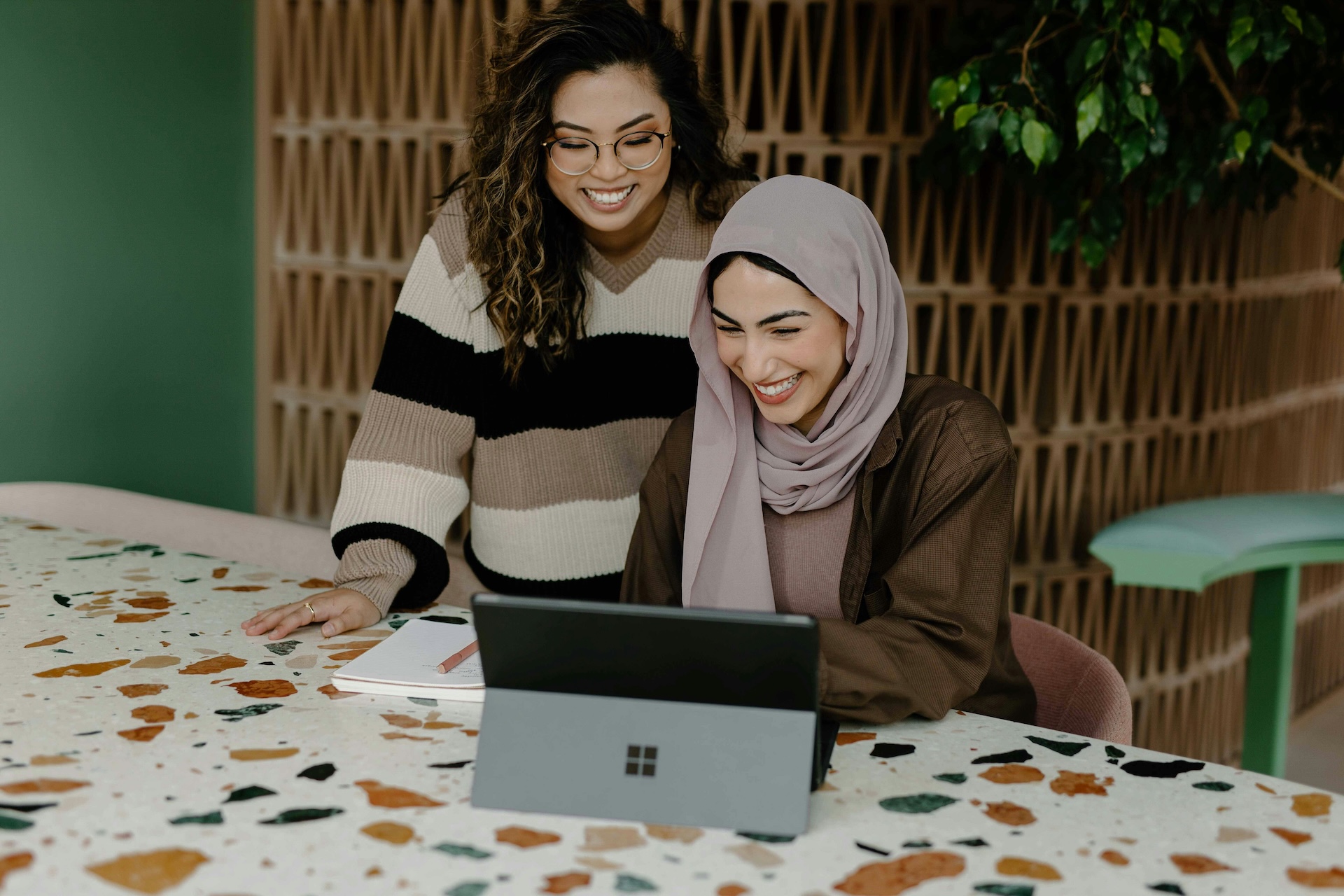 two women sitting with a laptop discussing shopify capital