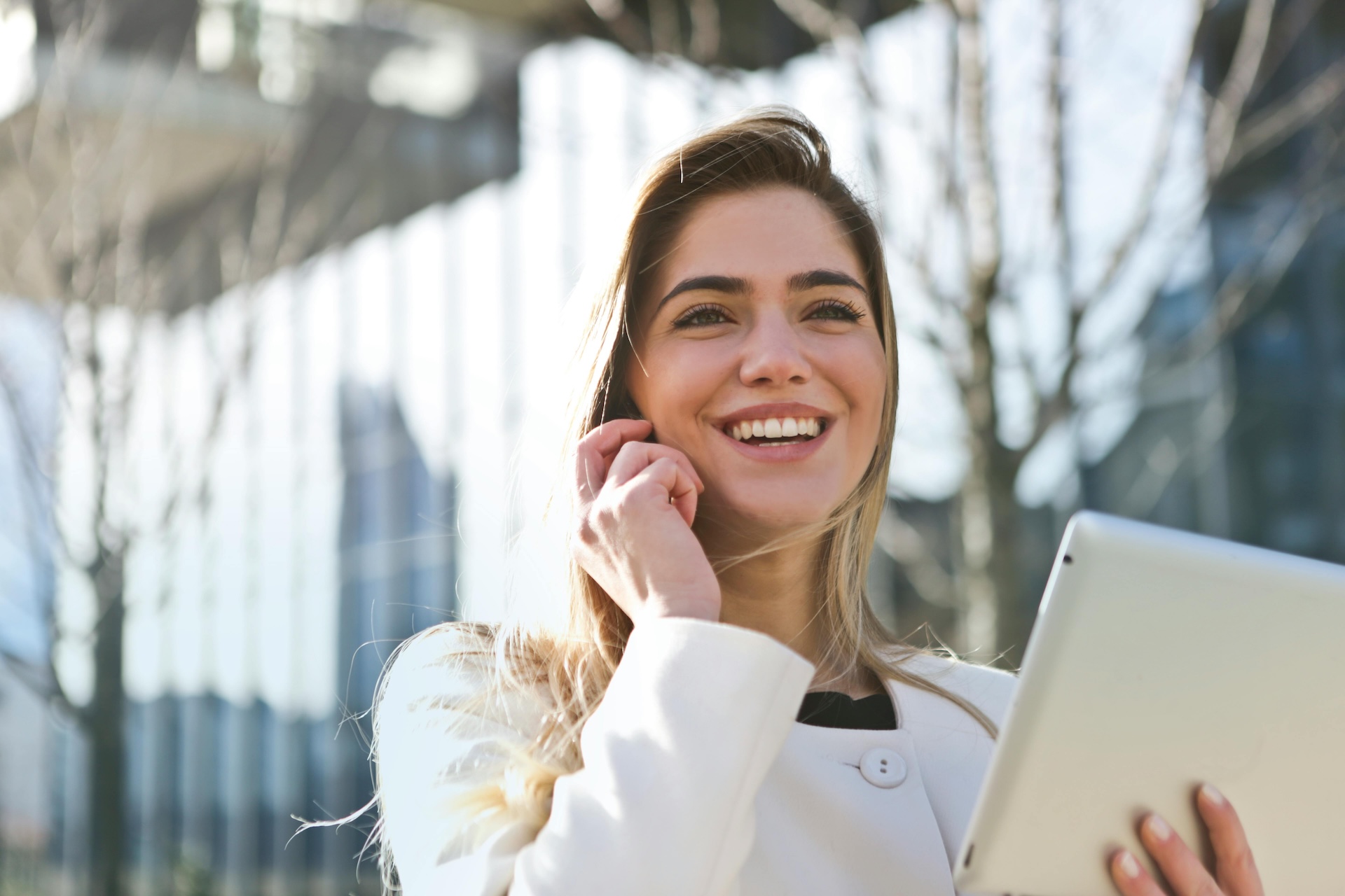 woman holding tablet on the phone smiling about good business credit