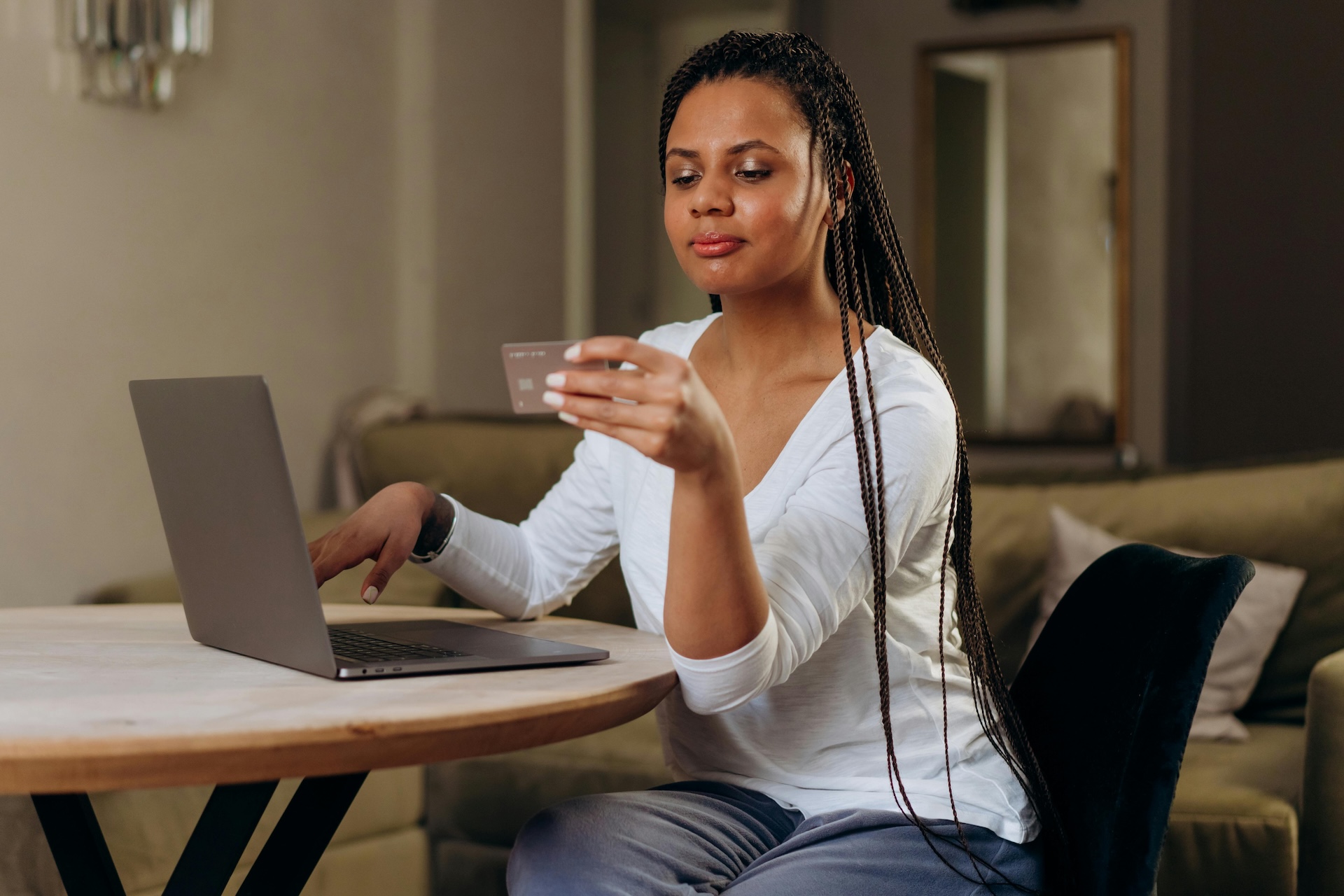 woman working on laptop holding business credit card